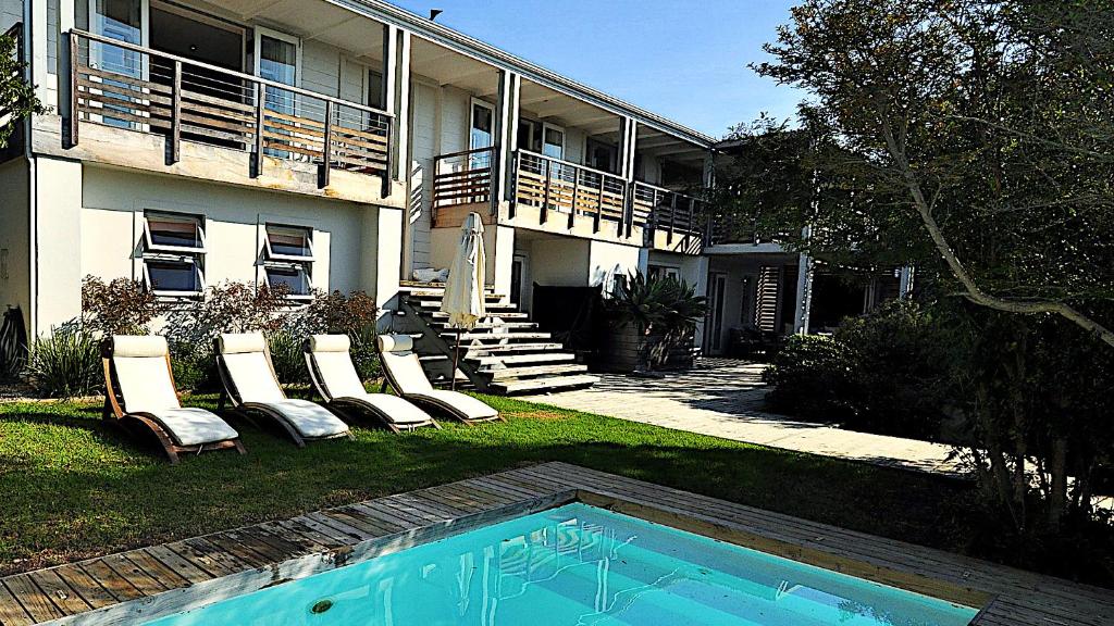una casa con sedie e una piscina nel cortile di Dassen Island 61 a Plettenberg Bay