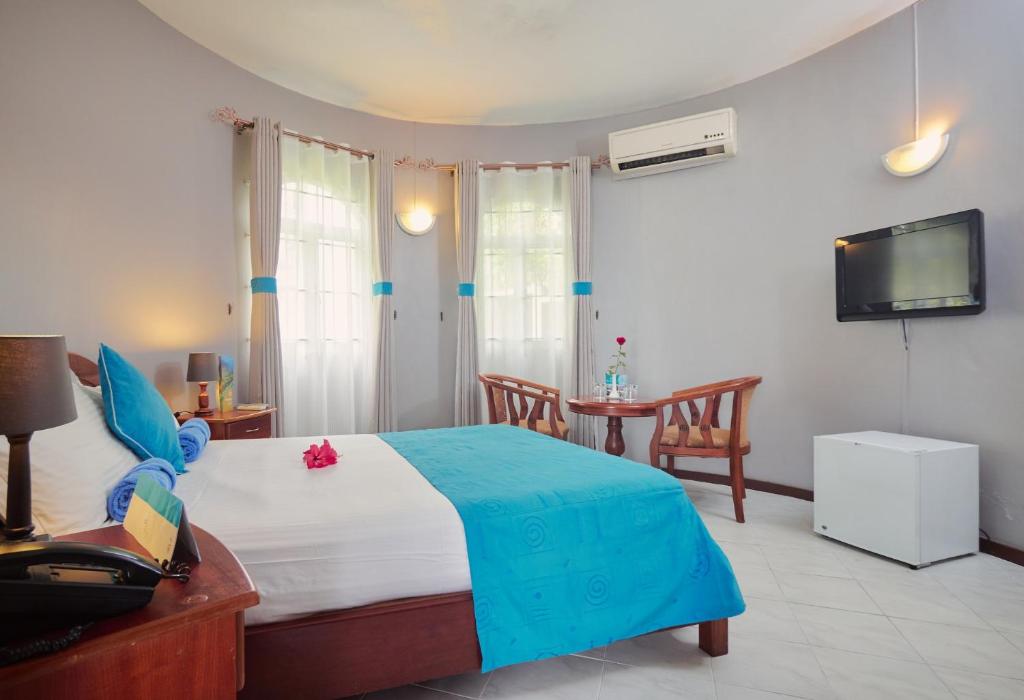 a bedroom with a large bed and a tv at Gold Beach Resort in Flic-en-Flac