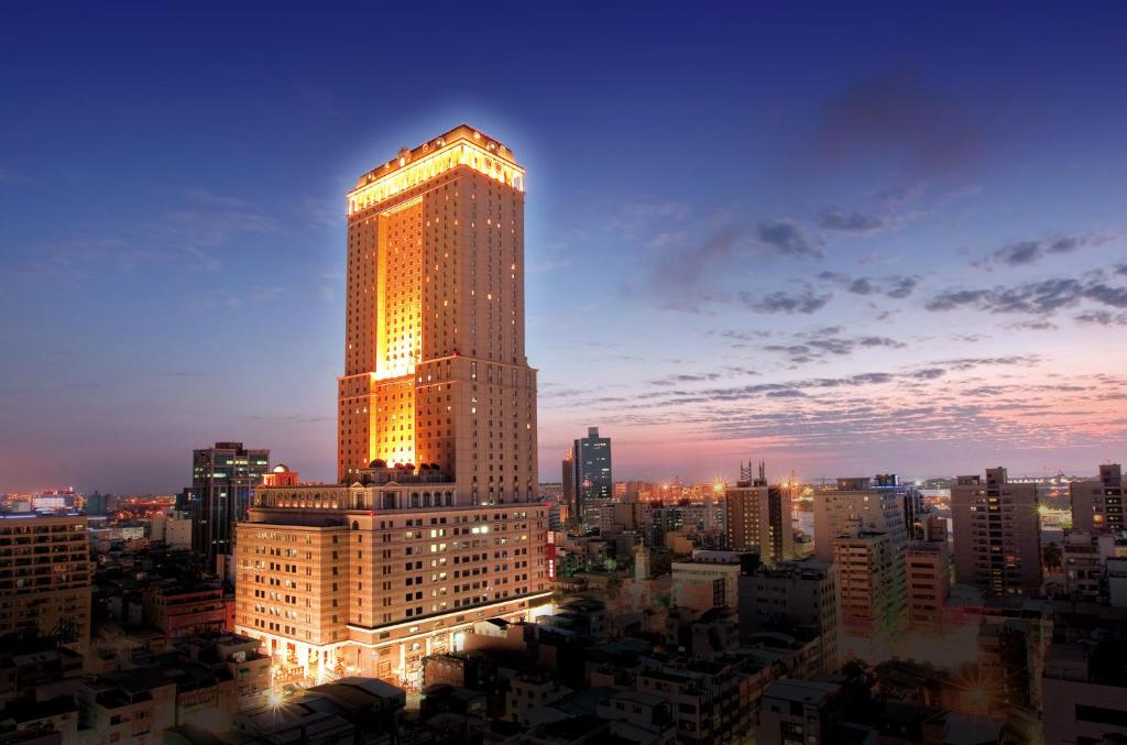 Un palazzo alto illuminato di notte in una città di Grand Hi Lai Hotel a Kaohsiung