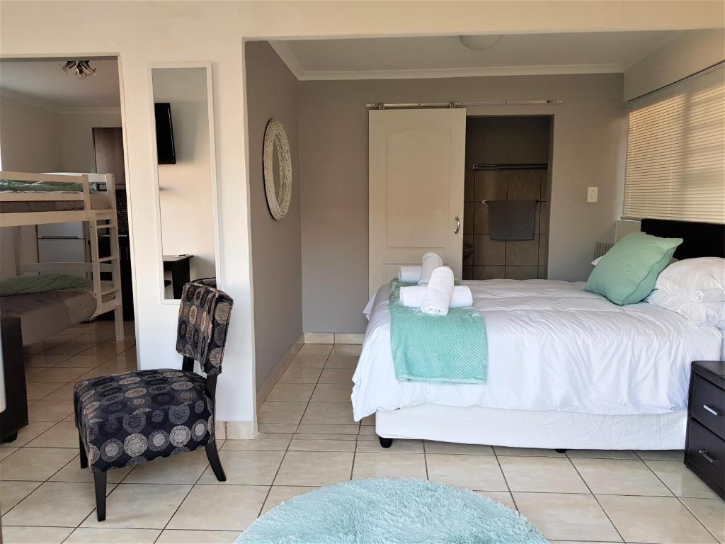 1 dormitorio con 1 cama grande y 1 silla en Comfey Stay, en Ciudad del Cabo