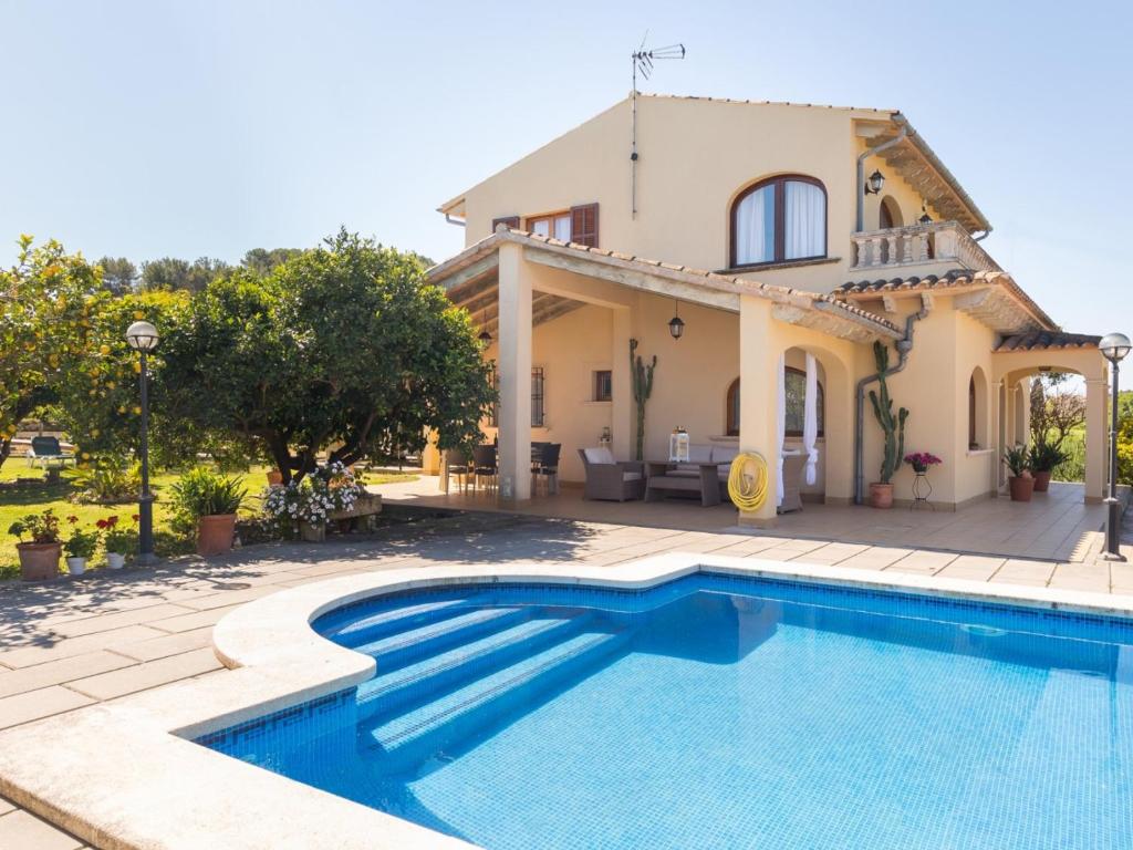 eine Villa mit einem Pool vor einem Haus in der Unterkunft Can miraet in Santa Margalida
