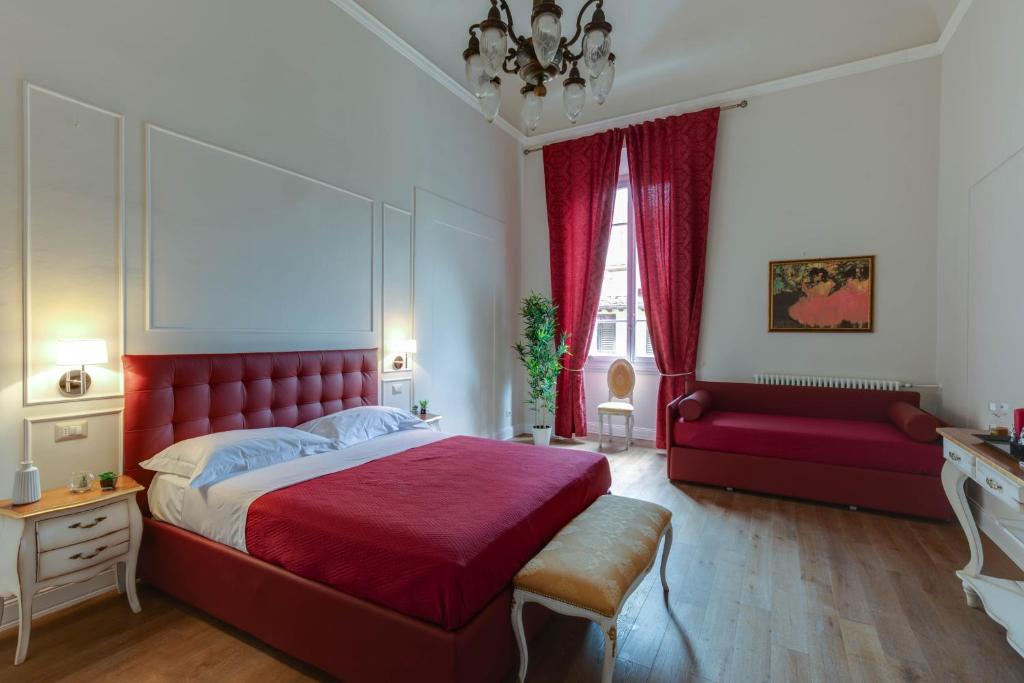 sypialnia z czerwonym łóżkiem i czerwoną kanapą w obiekcie Residenza d'Epoca Sant Egidio we Florencji