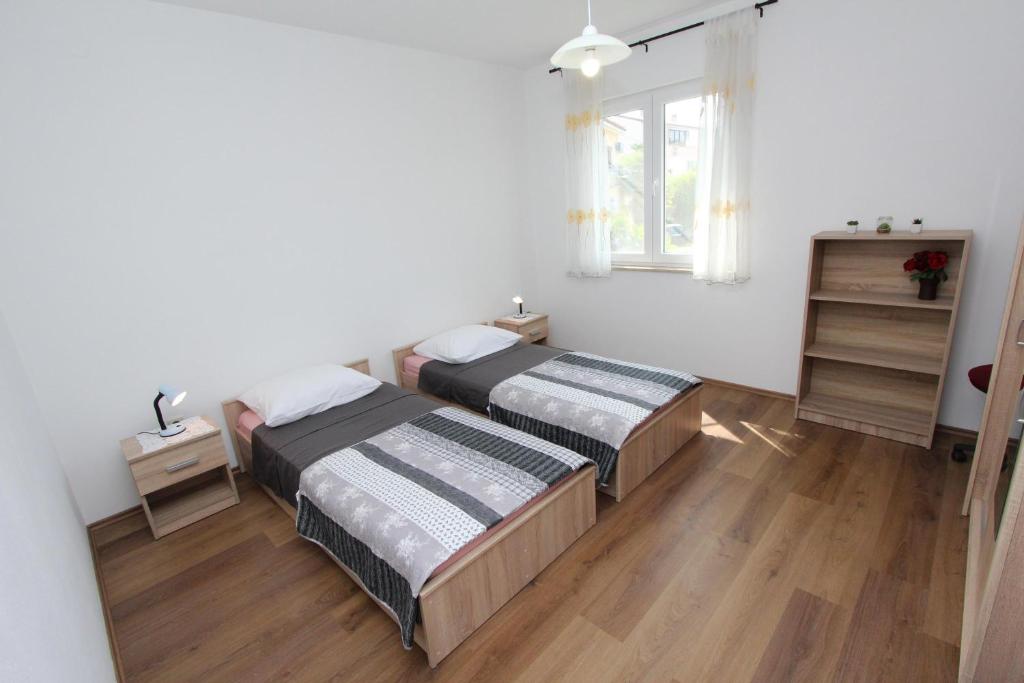 1 dormitorio con 2 camas y ventana en Apartment Dina, en Rovinj