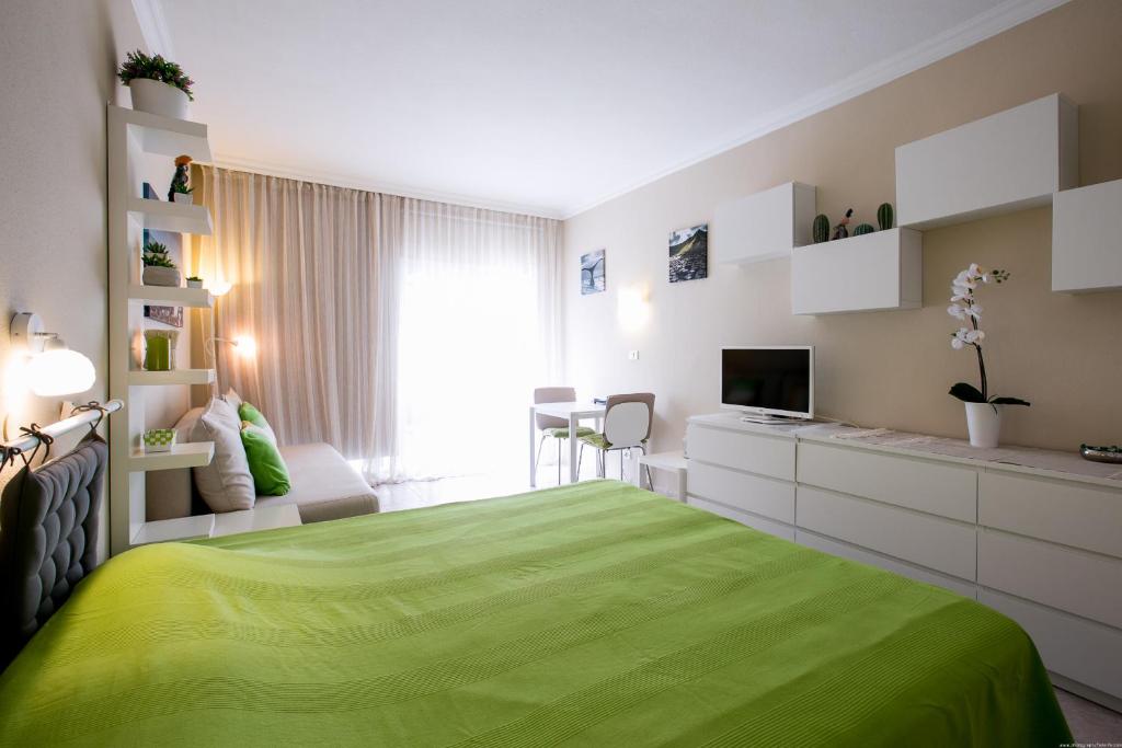 una camera con letto verde e televisore di Cozy apartment in Edificio Bahamas a Puerto de la Cruz