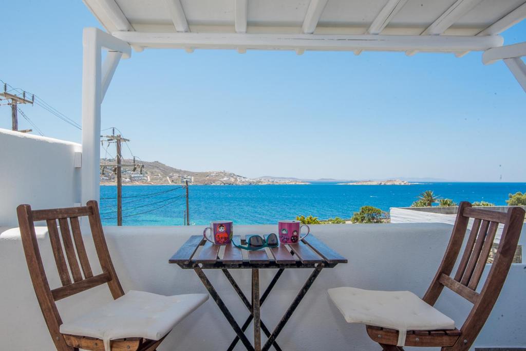 a table and chairs on a balcony with a view of the ocean at Beautiful Apartment With Amazing View, In Mykonos Old Town in Mýkonos City