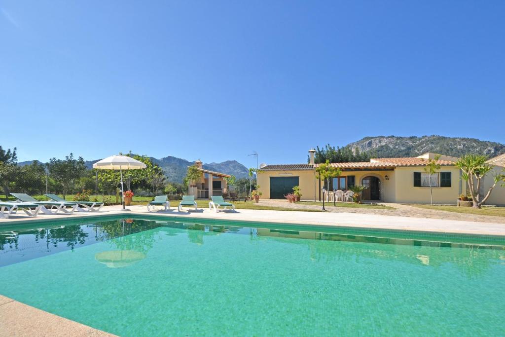 een groot zwembad met stoelen en een huis bij Villa Tabou in Selva