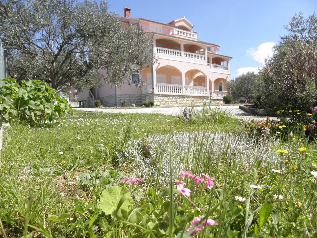 a large house with a garden in front of it at Rooms & Apartments Linda & Mario in Zadar