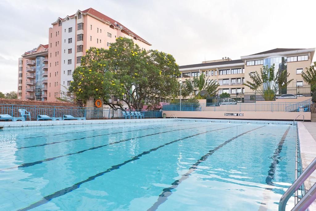 a large swimming pool with blue water in a city at Methodist Resort in Nairobi