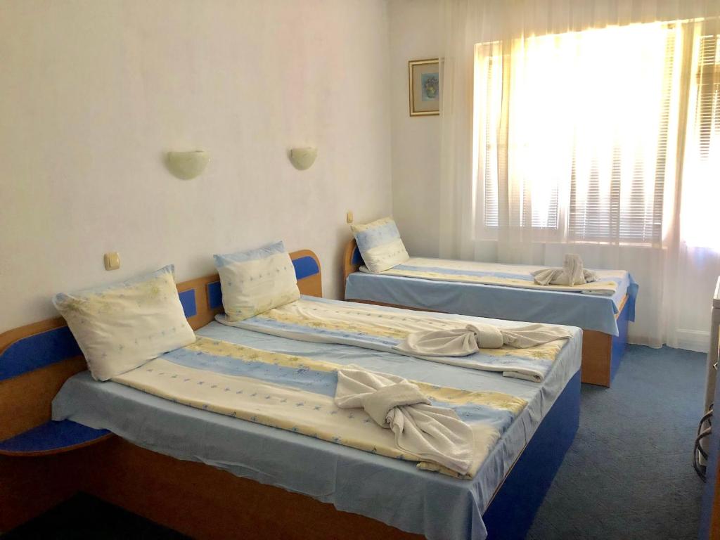 2 camas en una habitación con ventana en Guest House Rai en Kiten