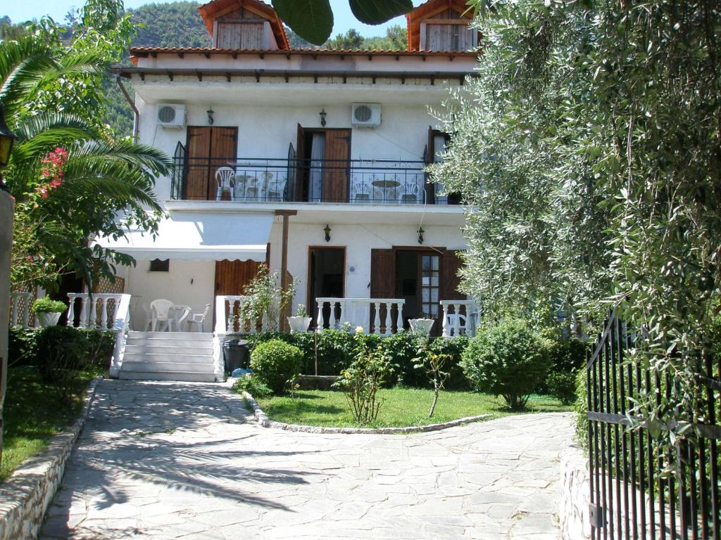 a white house with a balcony and a driveway at Viki Studios and Apartments in Skala Potamias