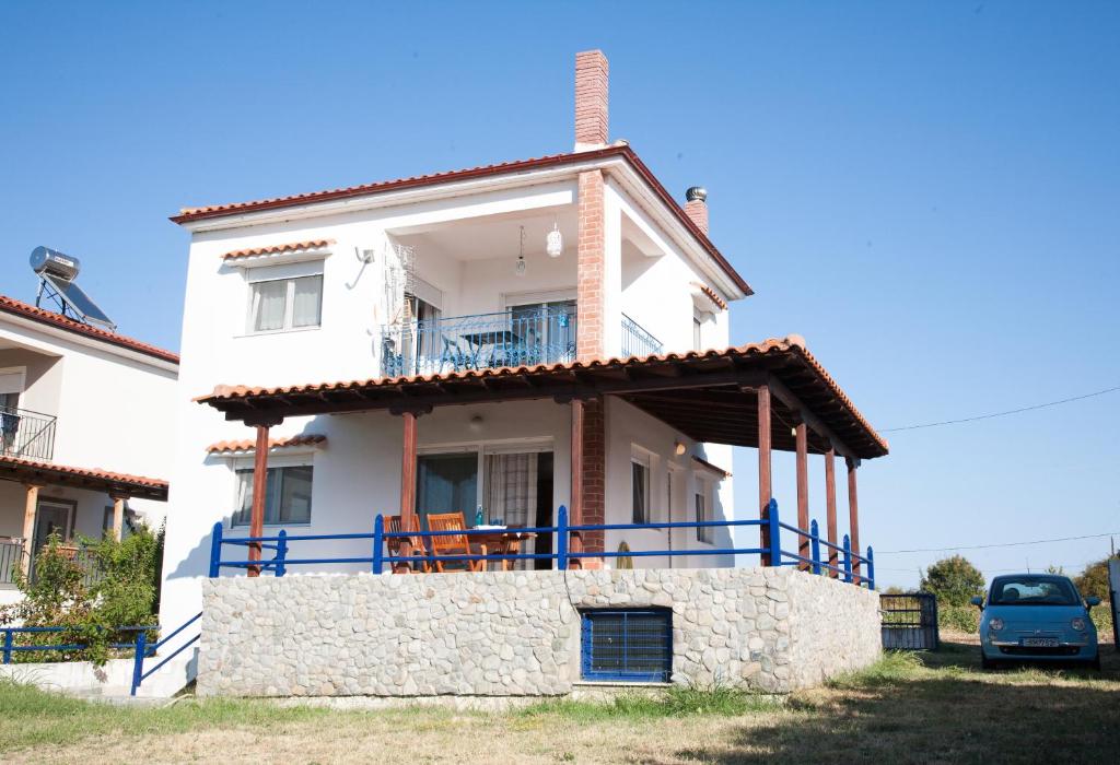 ein weißes Haus mit einem Balkon und einem Auto in der Unterkunft Villa Arogi in Aroyí