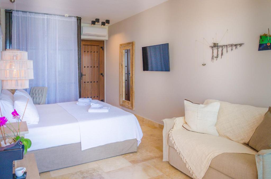 a bedroom with a white bed and a couch at Agorastos Hotel in Koinyra