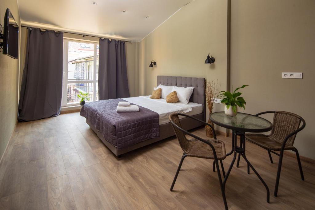 una camera con letto, tavolo e sedie di Poet Apartments a Odessa