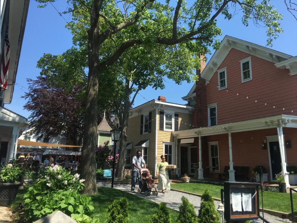 a man and a woman with a stroller in front of a house at American Beech Hotel in Greenport
