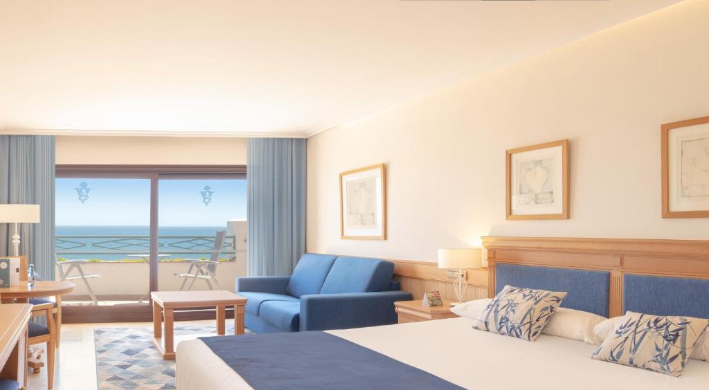 a hotel room with a bed and a blue chair at SH Villa Gadea in Altea