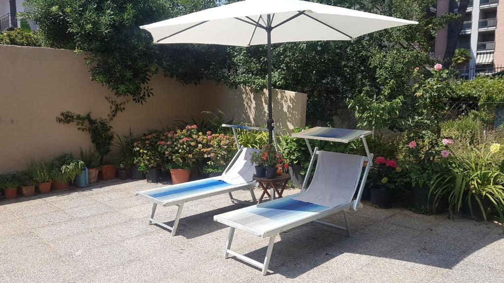 dwa krzesła i parasol na patio w obiekcie la maisonnette di anna w mieście Arma di Taggia