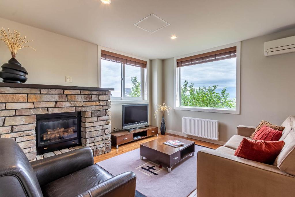 a living room with a couch and a fireplace at Fresh Powder Accommodation in Furano