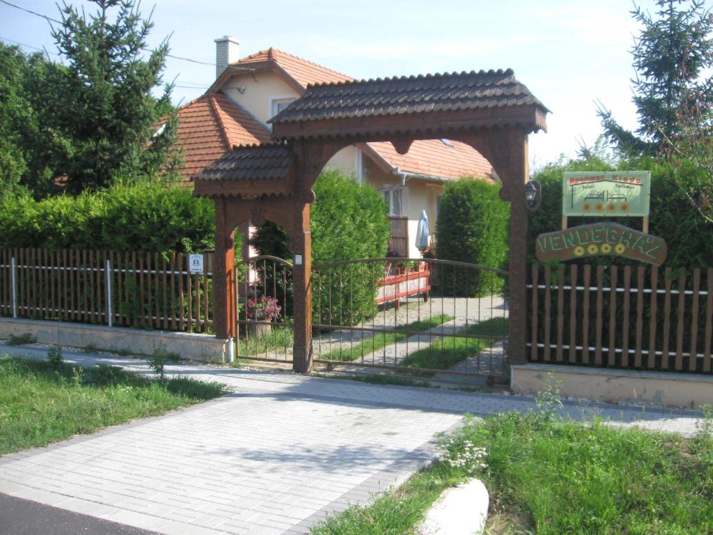 a wooden gate to a house with a fence at Négy Évszak Vendégház in Lukácsháza