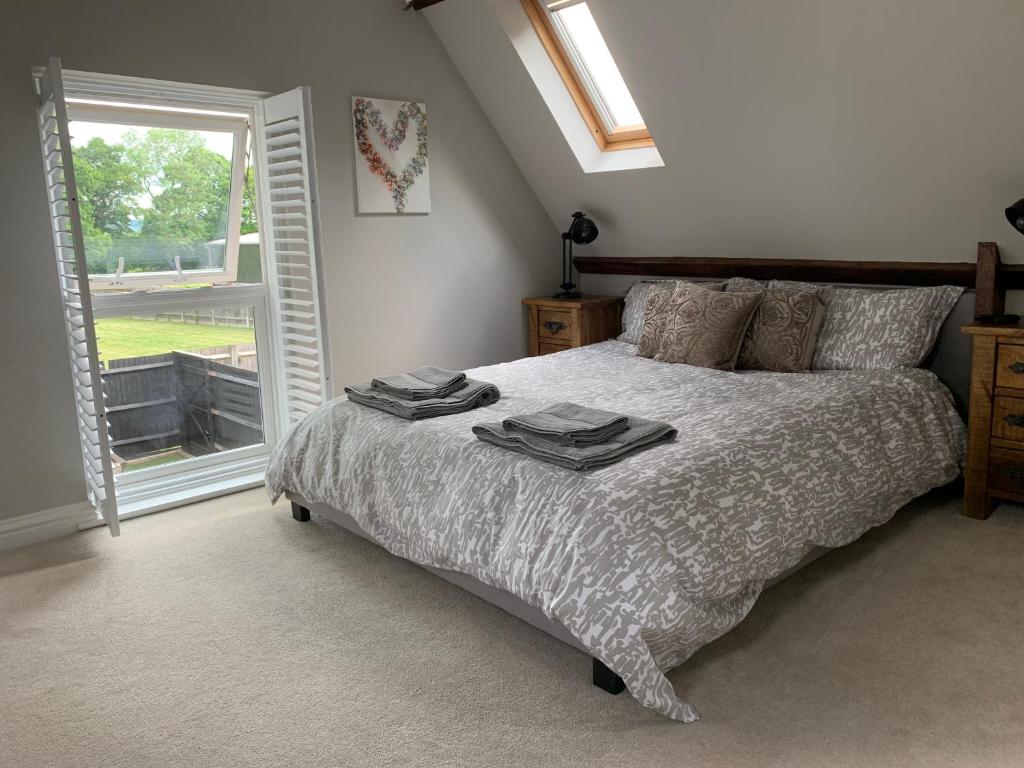 a bedroom with a bed with two towels on it at The Barn House in Cranleigh