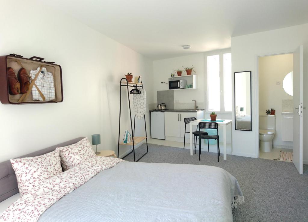 Cet appartement comprend une chambre avec un lit et une table ainsi qu'une cuisine. dans l'établissement Cool Places, à Limoges