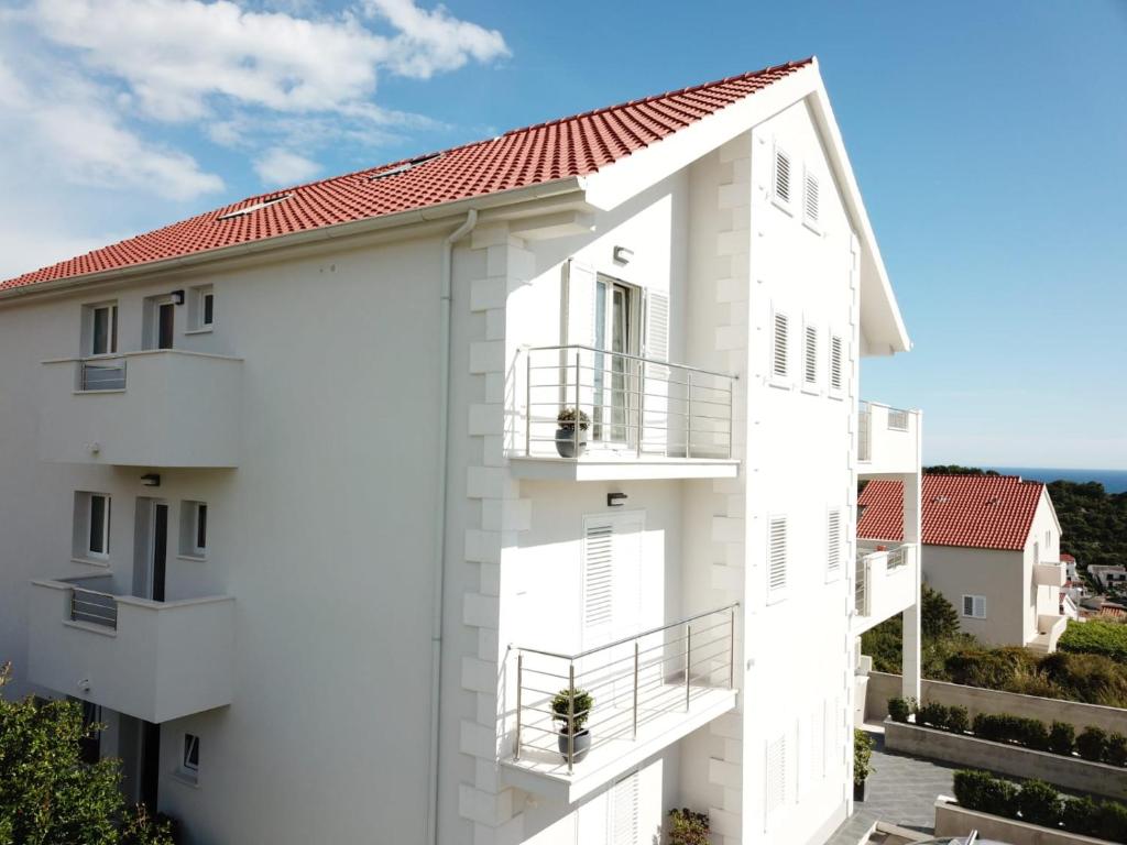 un edificio blanco con techo rojo en Hvar De Luxe Apartments, en Hvar