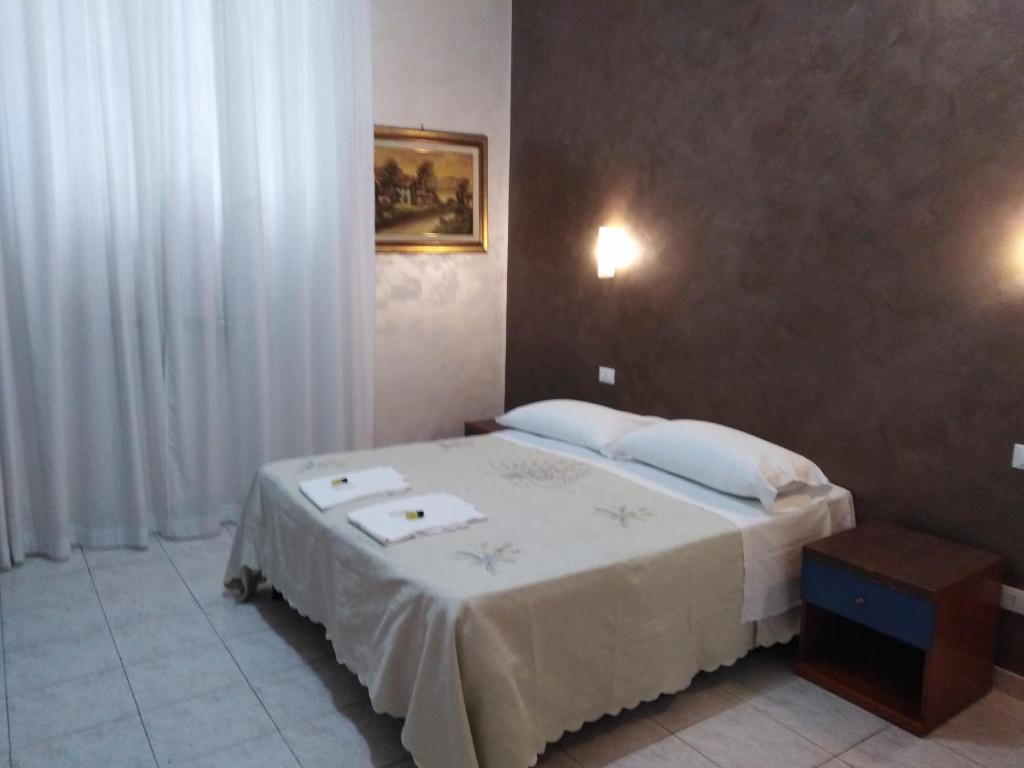 ローマにあるGloria Apartmentのベッドルーム1室(白いシーツと枕のベッド1台付)