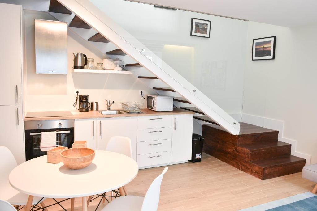 a white kitchen with a table and a staircase at Typical Quarter Nest in Porto