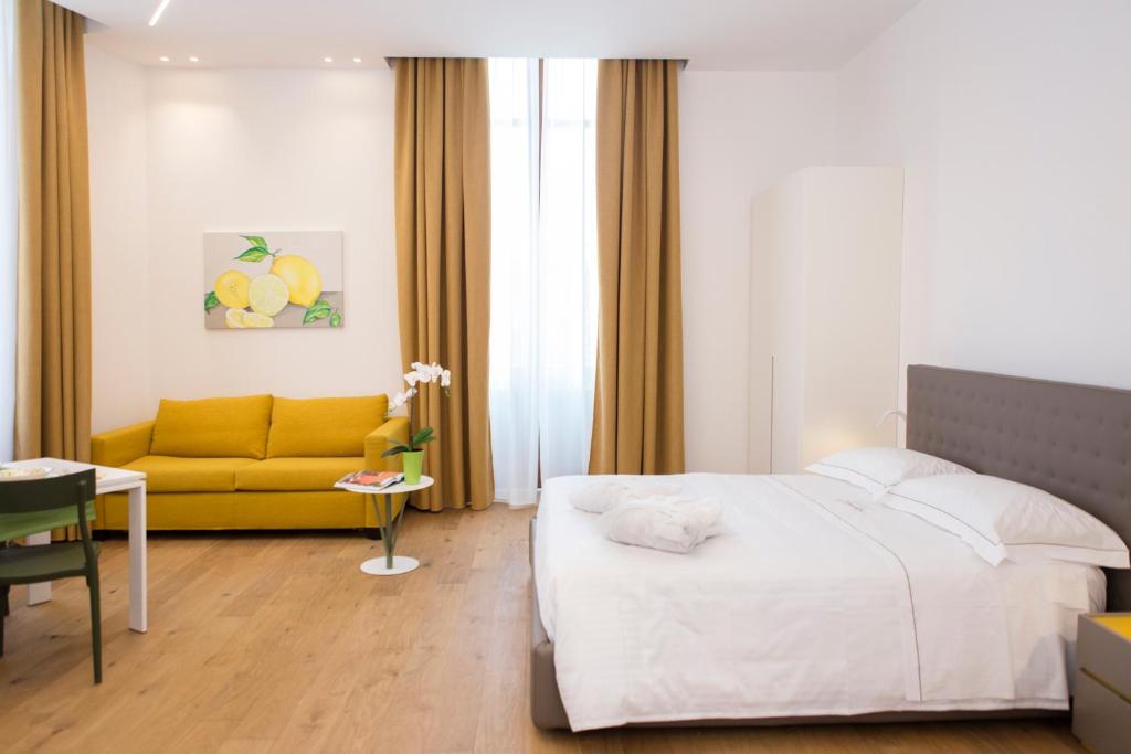 1 dormitorio con cama y sofá amarillo en Dimore Solara, en Catania