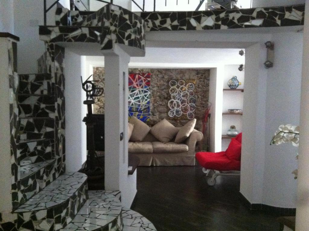 uma sala de estar com um sofá e uma cadeira vermelha em Cà d'Estrina em Bonassola