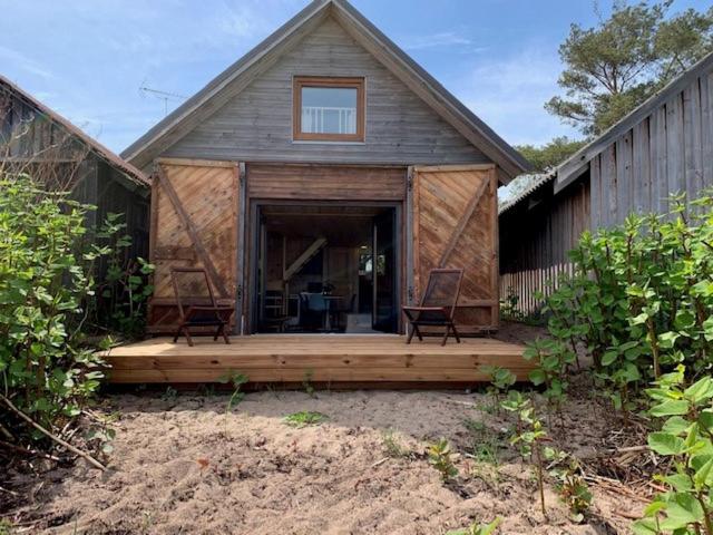 Una casa con un porche con dos sillas. en Small Vinter Summer House, en Käsmu