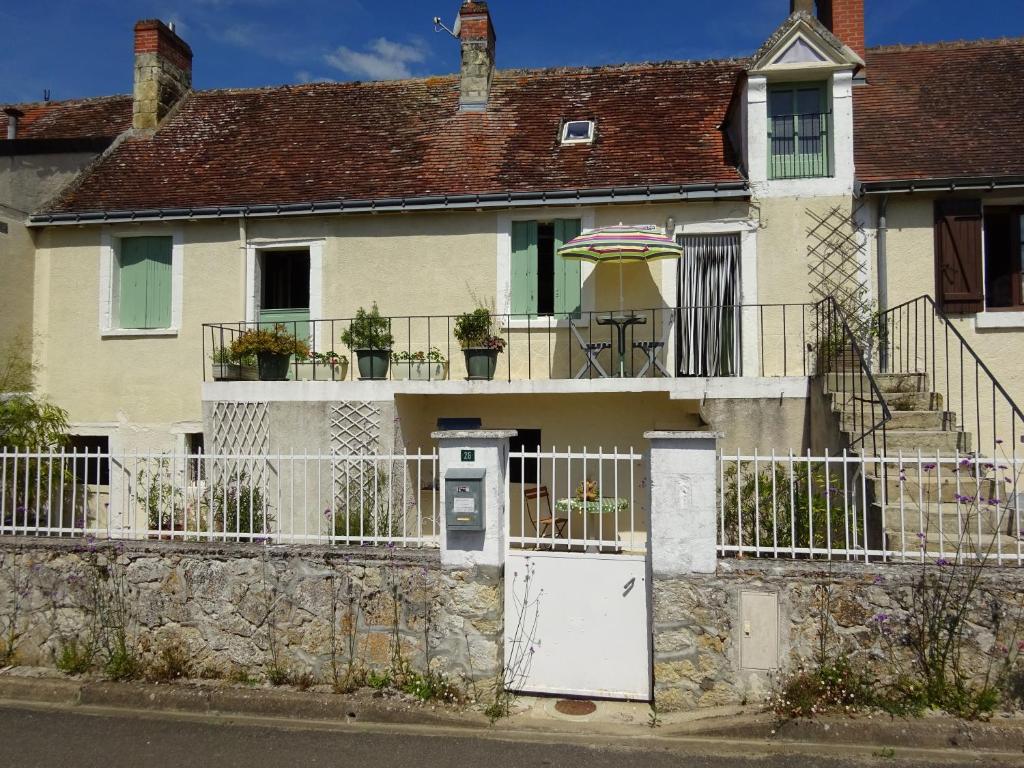 ein Haus mit einem weißen Tor und einem Zaun in der Unterkunft gite des tisserands in Ferrière-Larçon