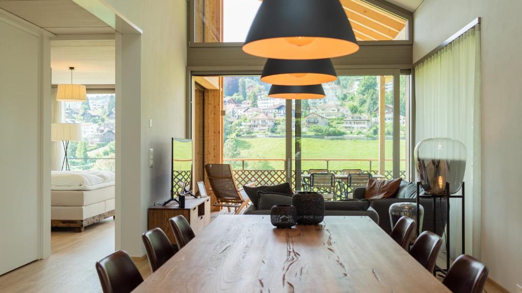 a dining room with a large wooden table and chairs at Seaside-Lodge, Top Apartment in Spiez