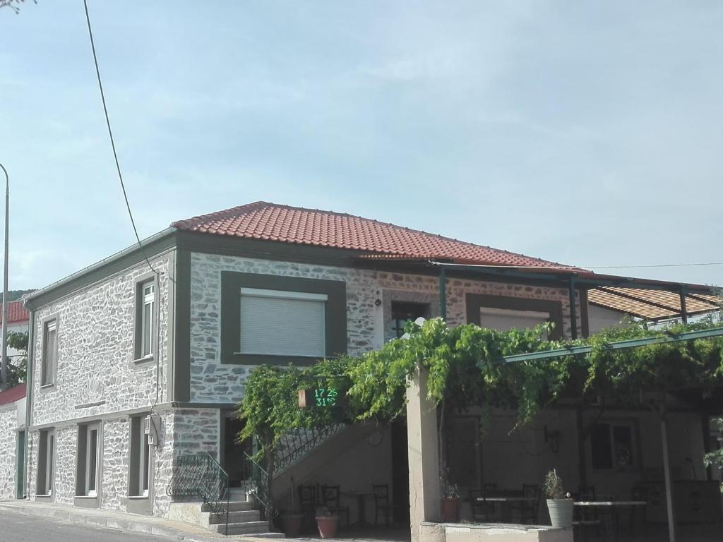 a brick house with a red roof on a street at Luxury Apartments in Áyios Andréas