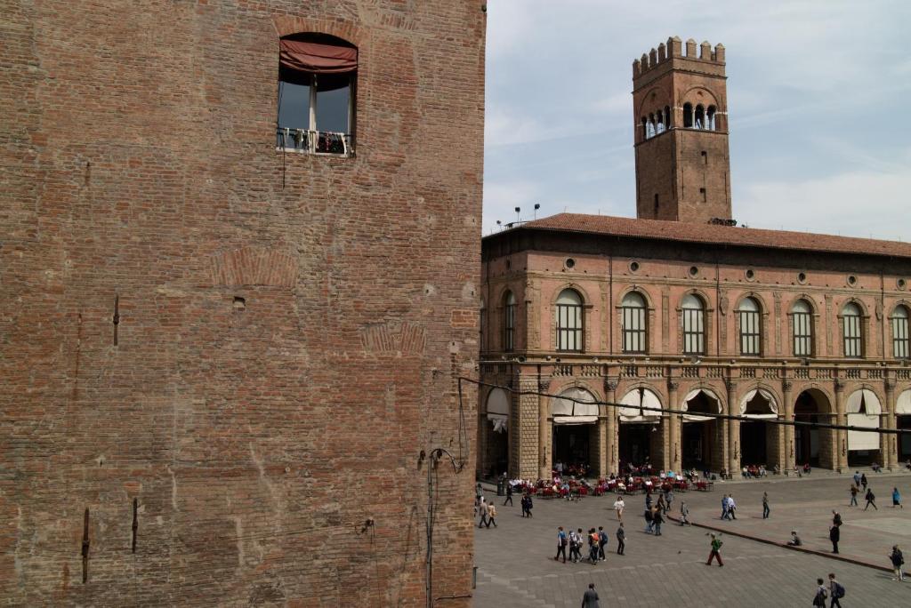 ボローニャにあるCasa Isolani Piazza Maggiore 1.0の時計塔のある大きなレンガ造りの建物