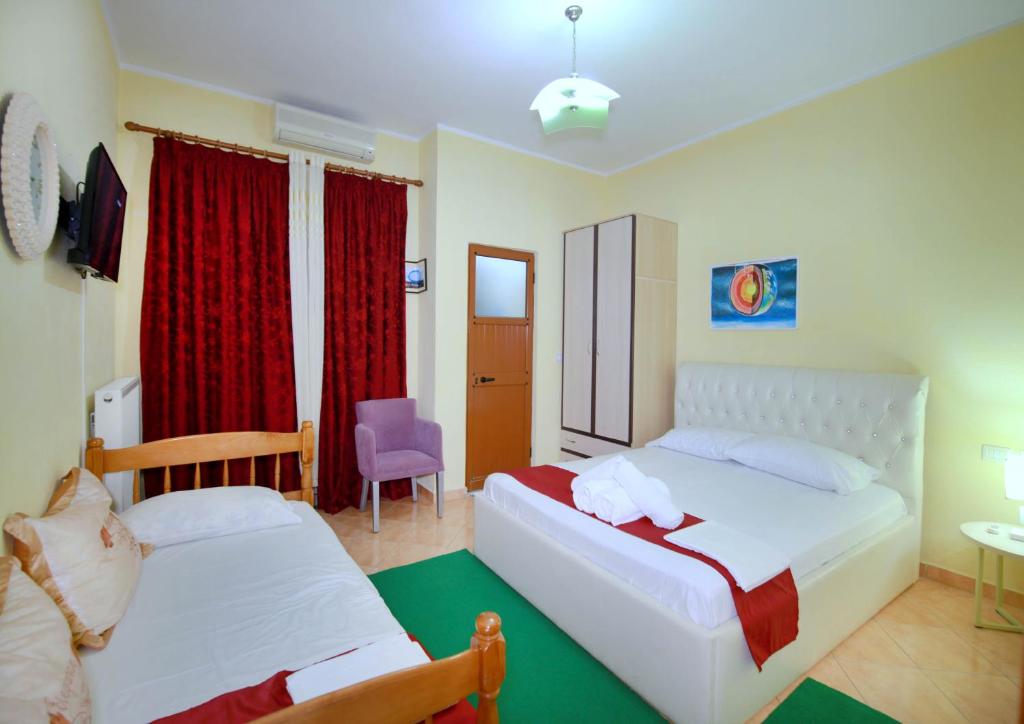 um quarto de hotel com duas camas e uma cadeira em My Home Guest House em Durrës