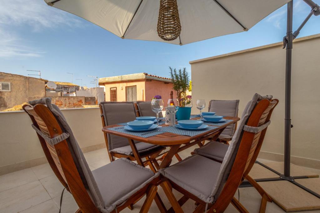 a table and chairs on a balcony with an umbrella at La Palazzata in Siracusa