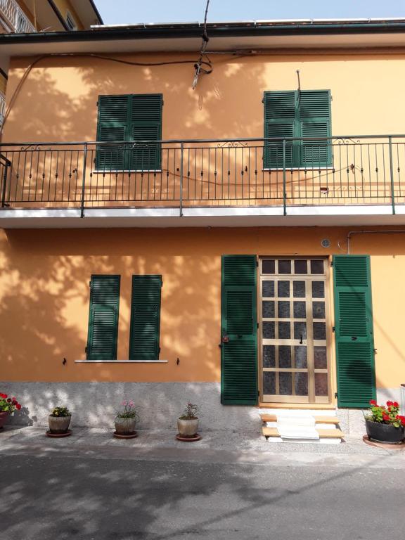 a building with green shutters and a balcony at OLGATAN in Deiva Marina