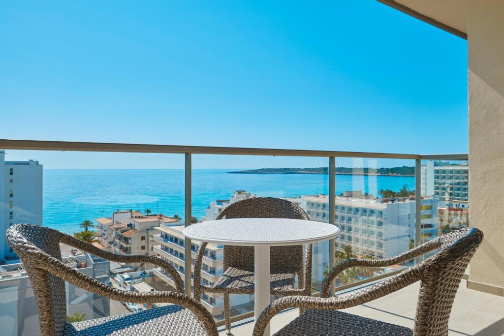 un tavolo e sedie su un balcone con vista sull'oceano di Protur Atalaya a Cala Millor