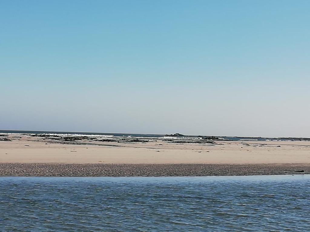 a beach with a body of water and the ocean at uilenkrallmond resort-cabin in Franskraal