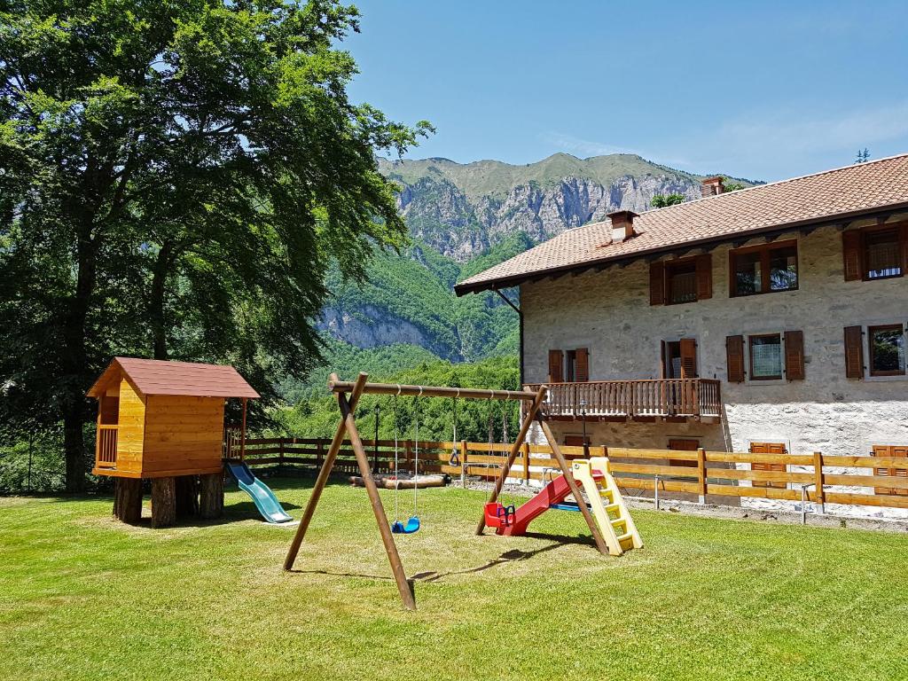 un parque infantil en un patio con una casa en Villa Paradiso Parolari, en Tenno