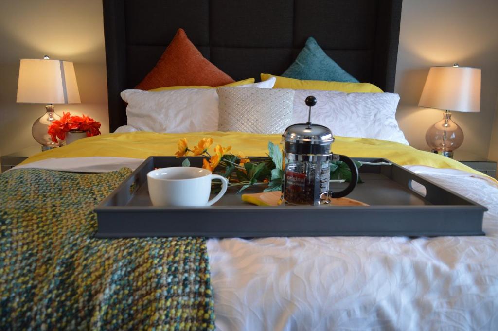 a tray with a coffee maker and a cup on a bed at Heathergate Cottage Dartmoor BnB in Lydford