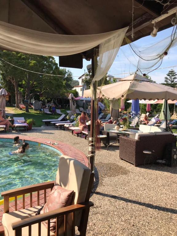 a pool with chairs and people in the water at Oasis in Skiathos
