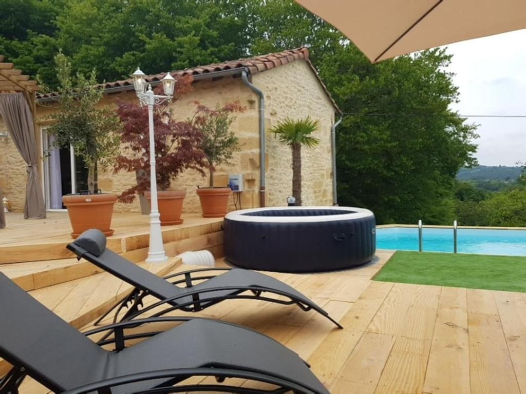 un patio con una hoguera y una piscina en Le Clos des Bories Le Gîte, en Sarlat-la-Canéda