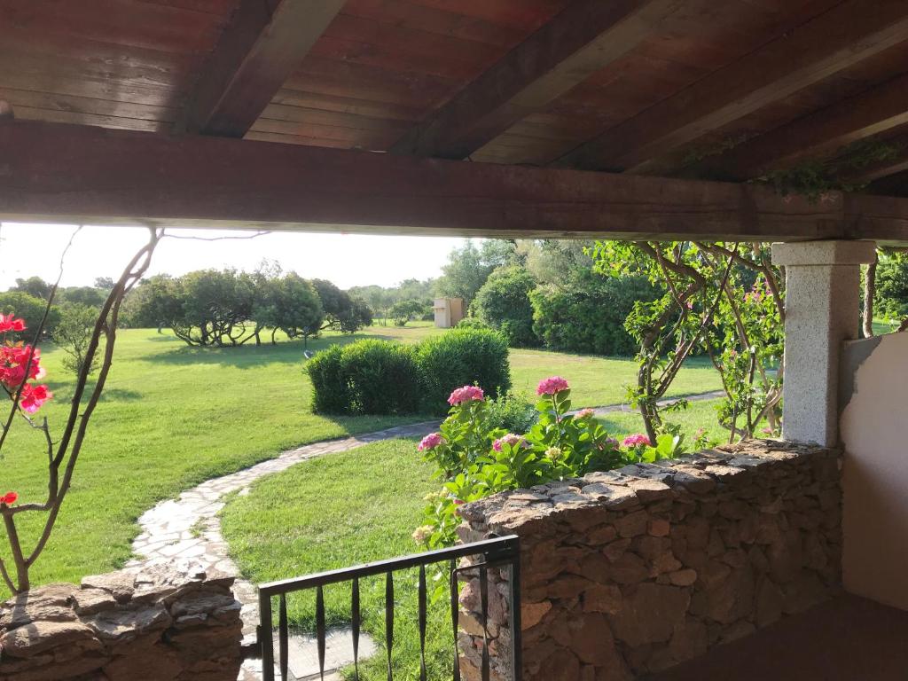 a view of a garden from the porch of a house at Visit San Teodoro in San Teodoro
