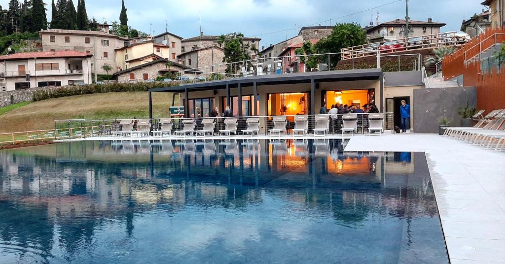 un edificio con una piscina d'acqua di fronte ad esso di Stella D'Oro - Hotel & Apartments a Tremosine Sul Garda