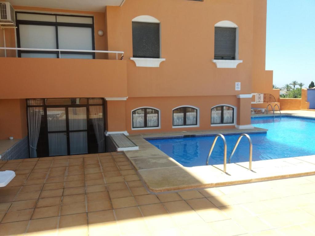 een villa met een zwembad in een gebouw bij Estudio Fenix LOS MOLINILLOS in Roquetas de Mar