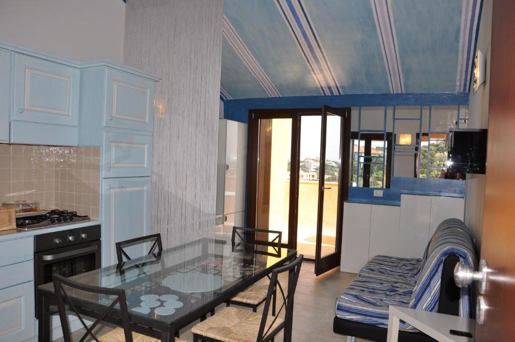 a kitchen with a table and chairs in a room at Attico Romantico vista mare alla Maddalena in La Maddalena