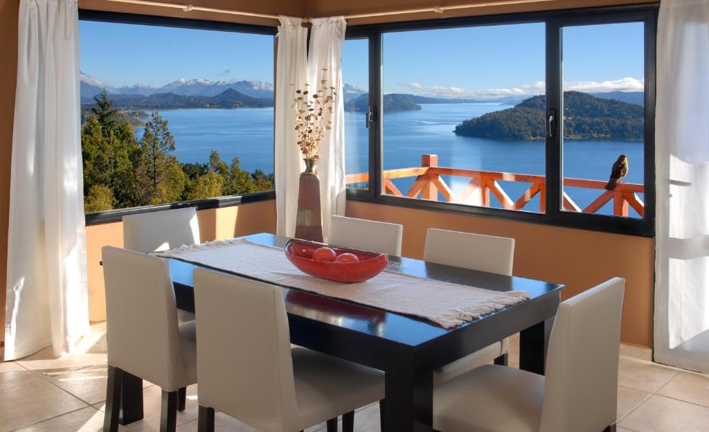 a dining room with a table and chairs and a large window at Catalonia Sur Aparts-Spa in San Carlos de Bariloche