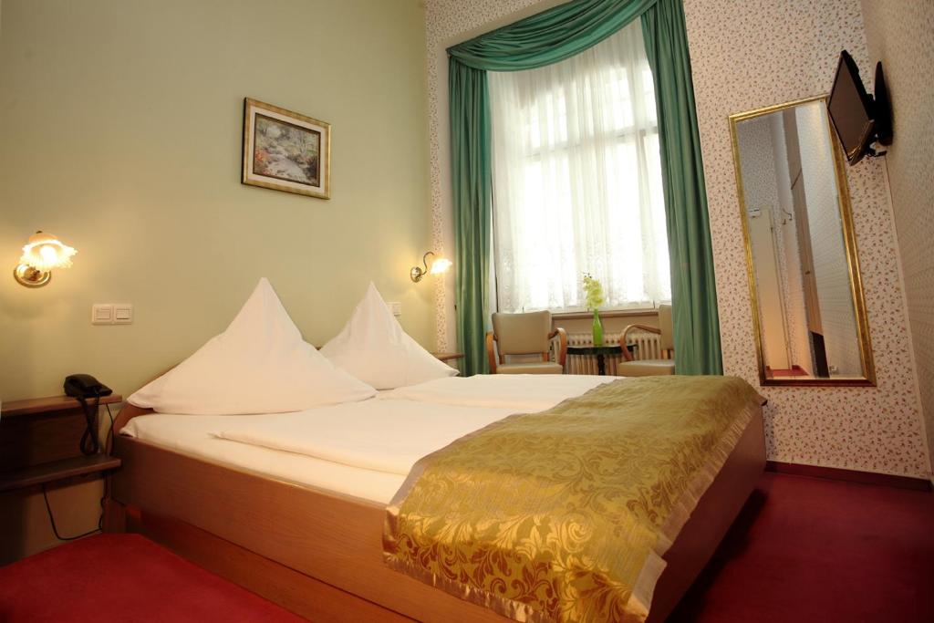ein Hotelzimmer mit einem großen Bett in einem Zimmer in der Unterkunft Astoria Hotel in Trier