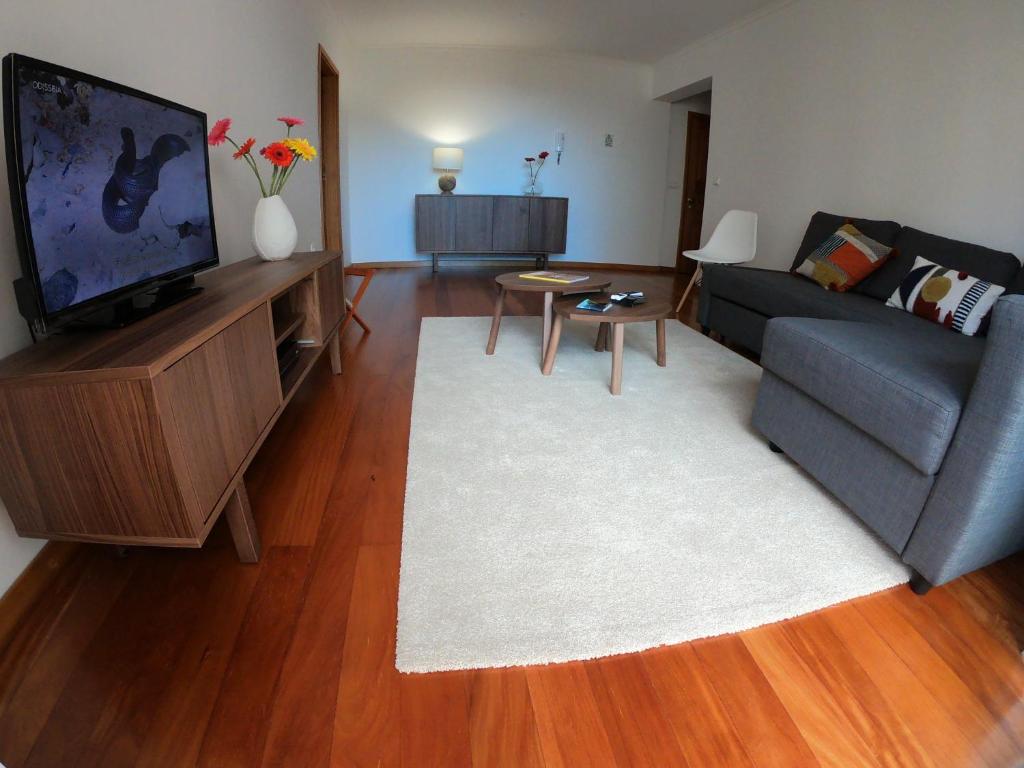 sala de estar con sofá y TV de pantalla plana en Freda House en Funchal